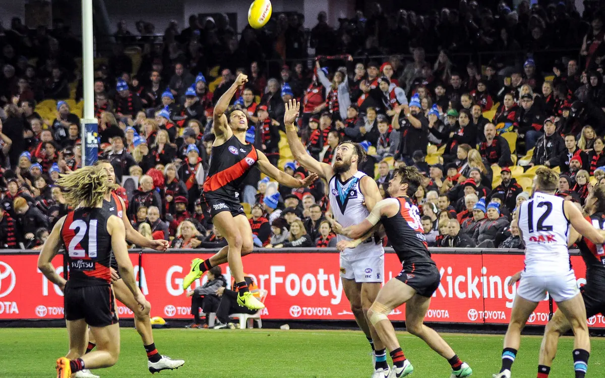AFL players leaping in a marking contest in front of a packed crowd