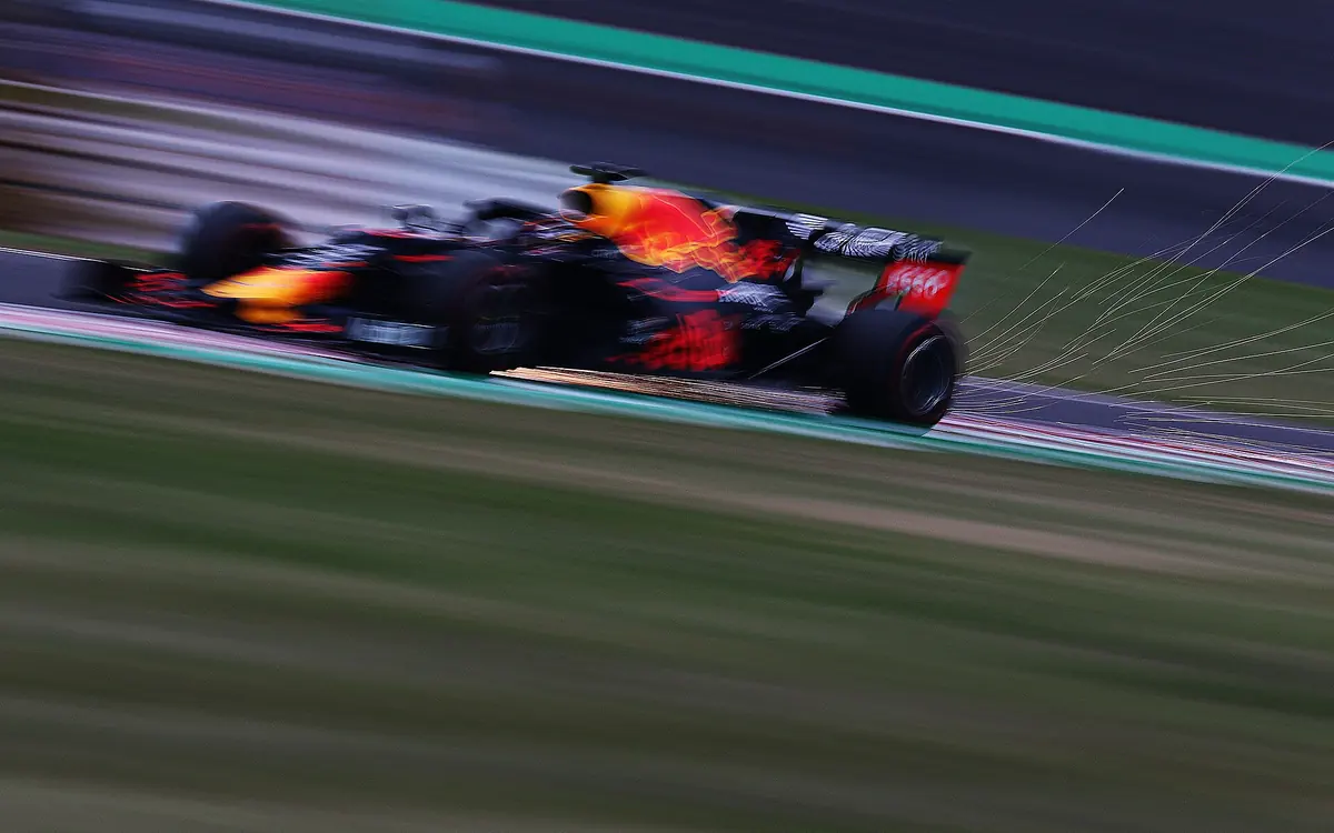 A Formula 1 car at full speed on track, panned with motion blur