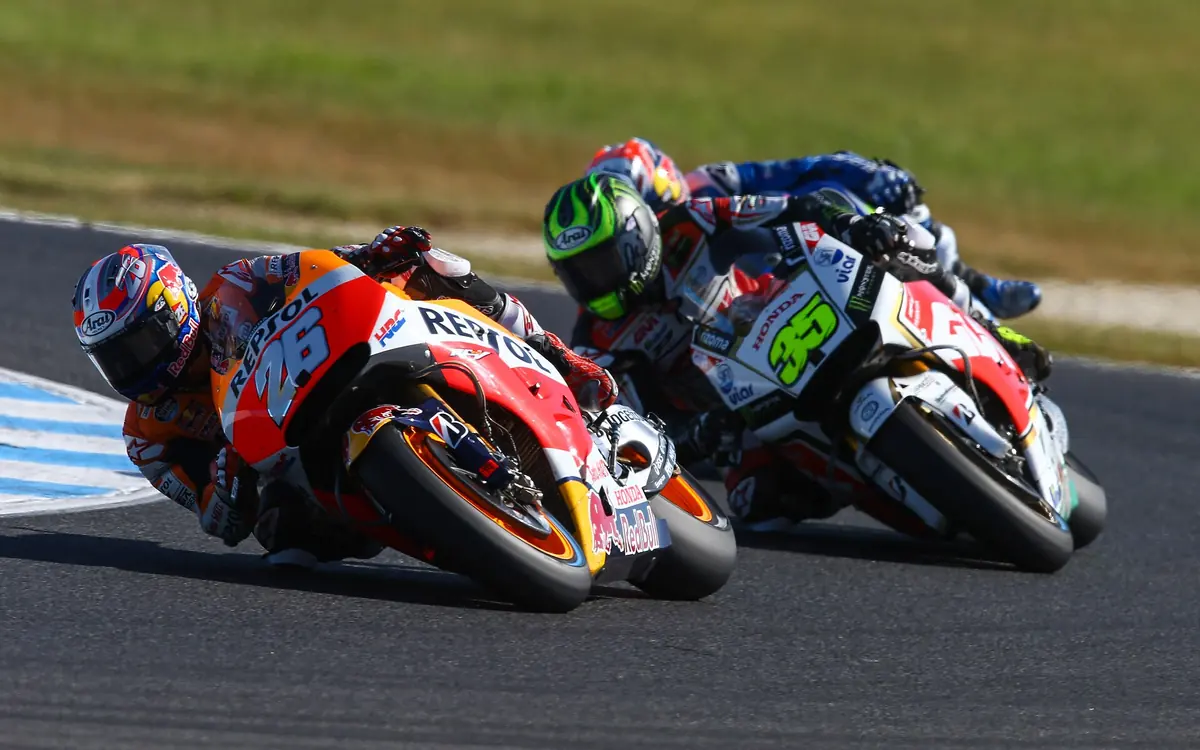 Two MotoGP riders leaning hard through a corner at speed